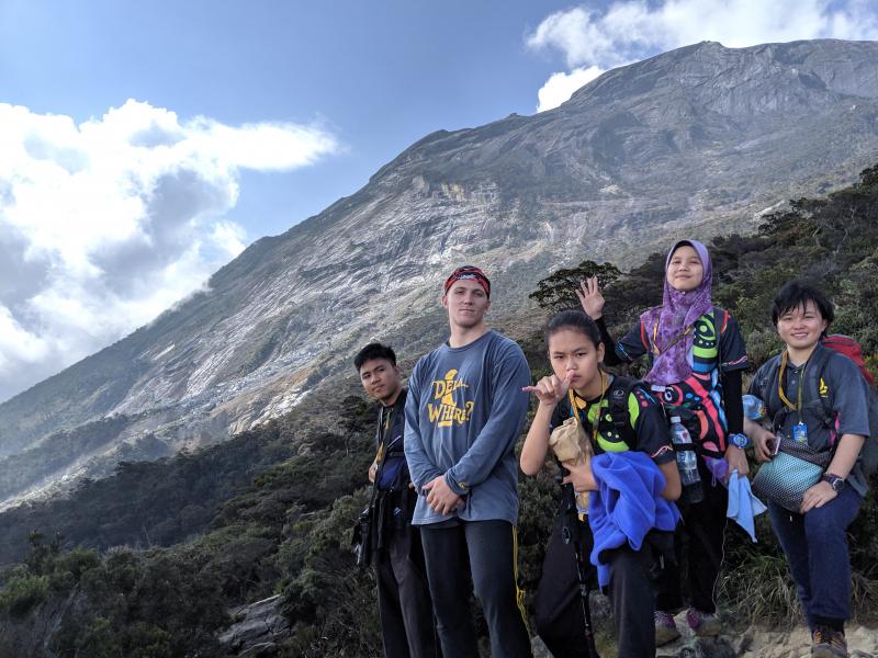 Students climbed Mt. Kinabalu, the tallest mountain on Borneo and a centerpiece of Sabahan culture, during a sponsored trip for which they applied by writing an essay and being interviewed in English. Pictured with Kammerer in his DelaWhere? T-shirt are students (l-r) Adib, Ivy, Dewi and Lydia.